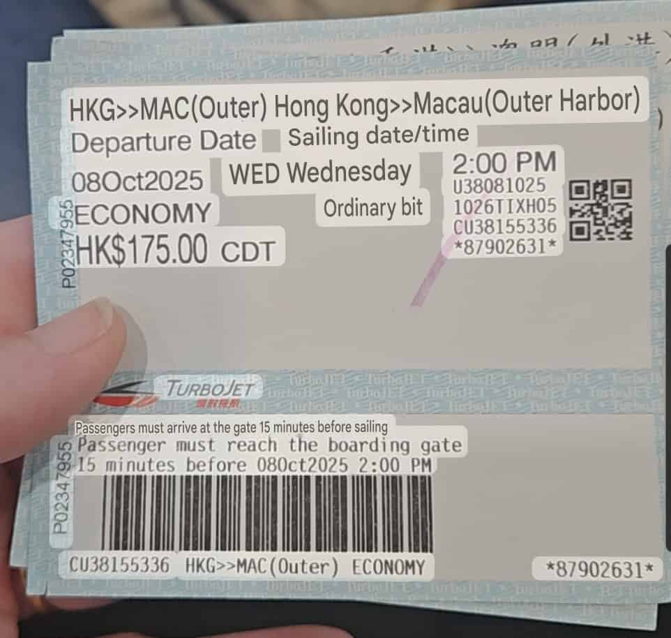 Hand holding a TurboJET ticket for the Hong Kong to Macau ferry showing route "HKG>>MAC(Outer) Hong Kong>>Macau(Outer Harbor)", date "08Oct2025 WED Wednesday", time "2:00 PM", class "ECONOMY", and price "HK$175.00 CDT", with a QR code and barcode visible.