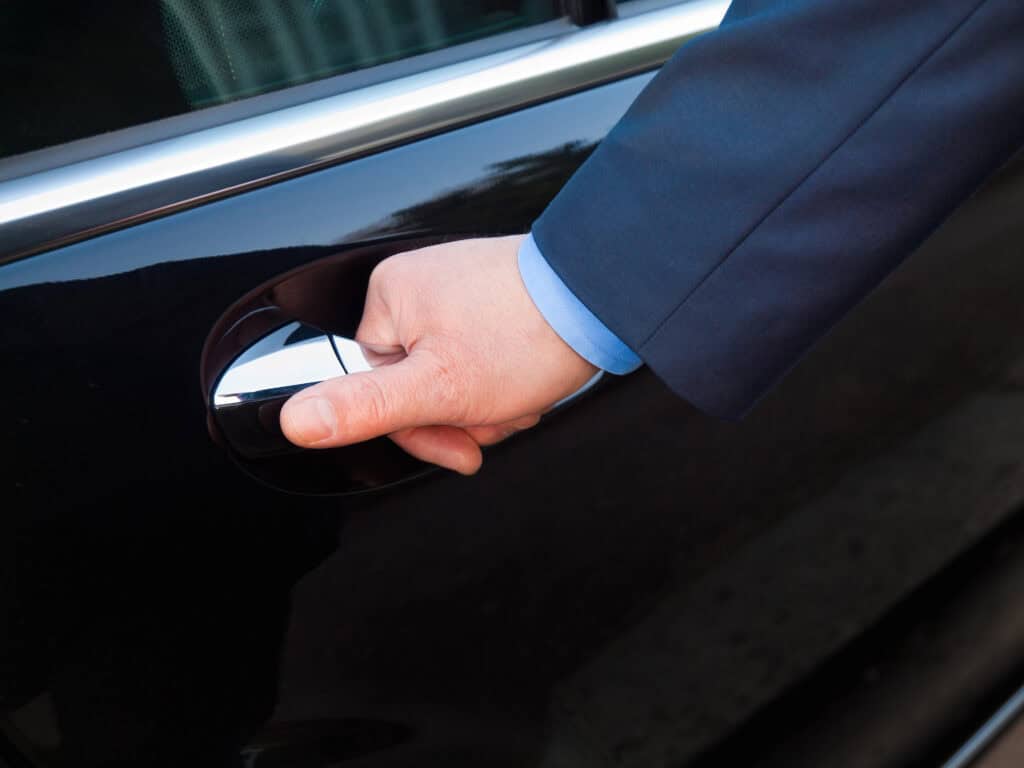 Close up of a hand opening a car door, representing a private transfer option from Hong Kong to Macau as an alternative to the ferry.