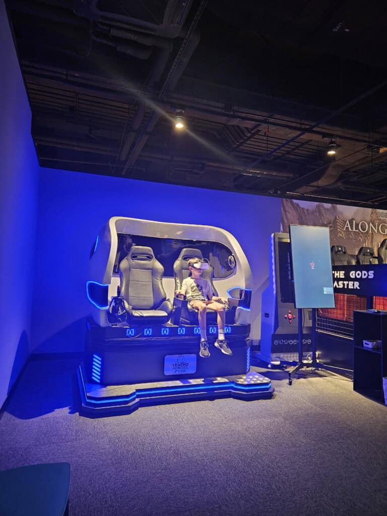 VR gaming experience inside a Macau entertainment complex, with a child using a virtual reality simulator ride.